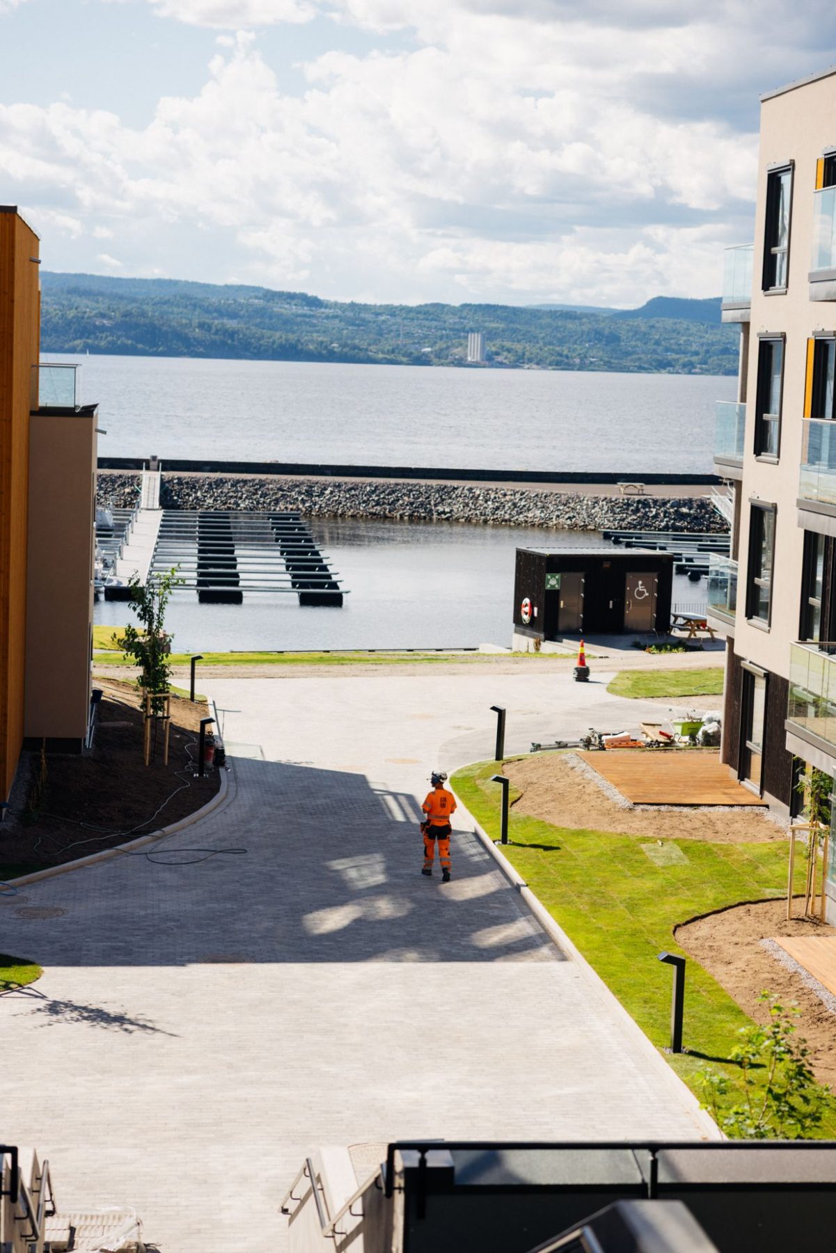 Fagarbeider fra Oliva Park går gjennom et ferdig uteområde med utsikt mot sjøen